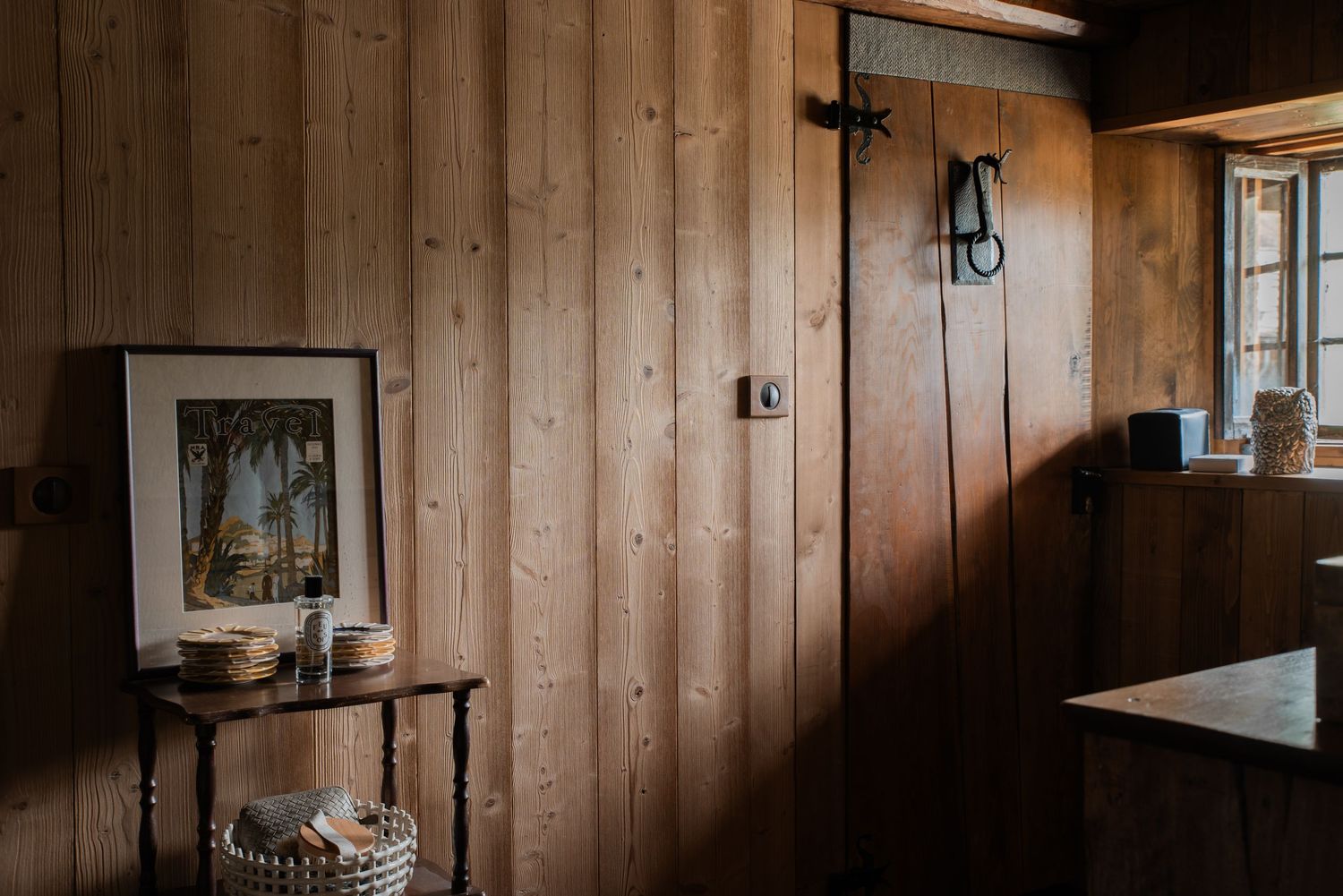 Rustic wooden paneled walls with natural lighting in a cozy interior space.