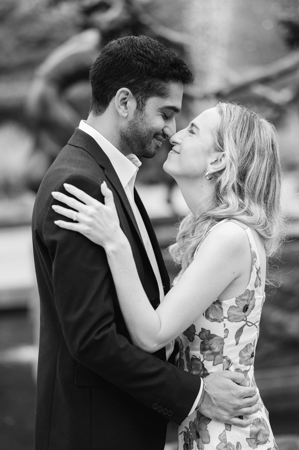 Romantic couple embraces in black and white photo series showing tender moments in a garden setting.