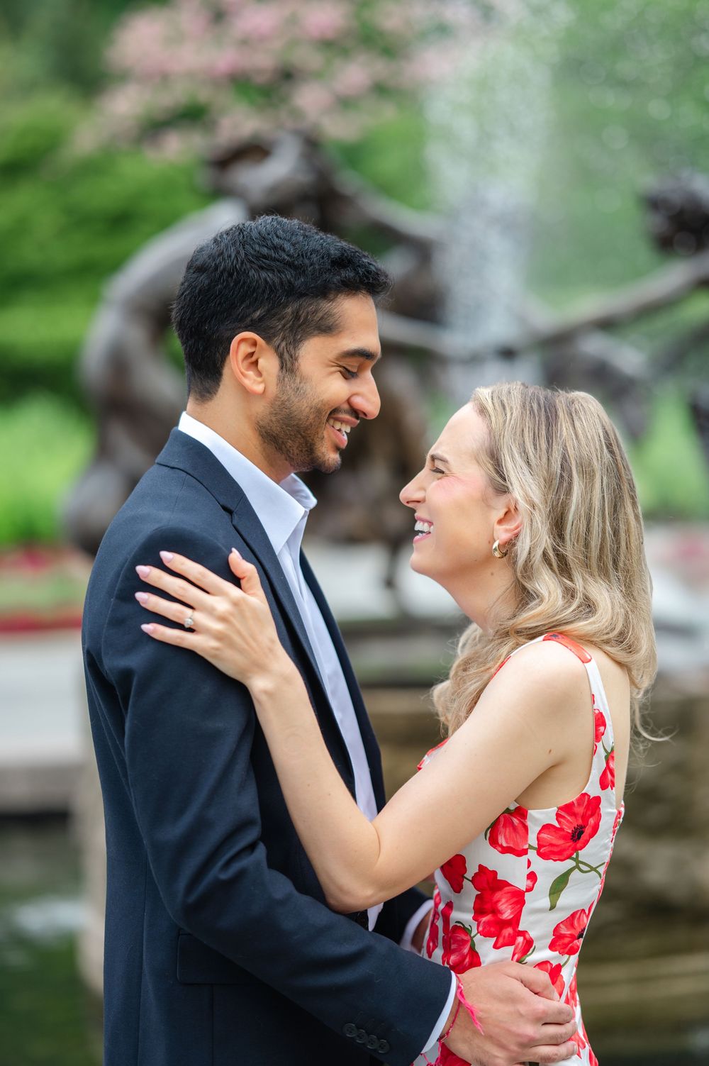 Romantic couple shares intimate moments while dressed in formal attire near a garden setting.