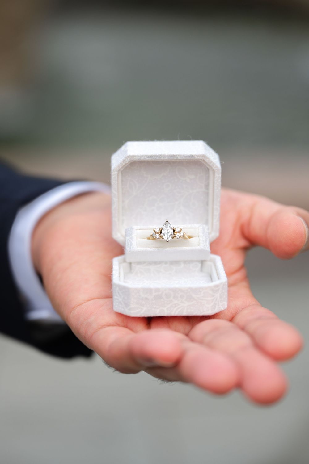 Close-up shots of a white ring box containing an engagement ring.