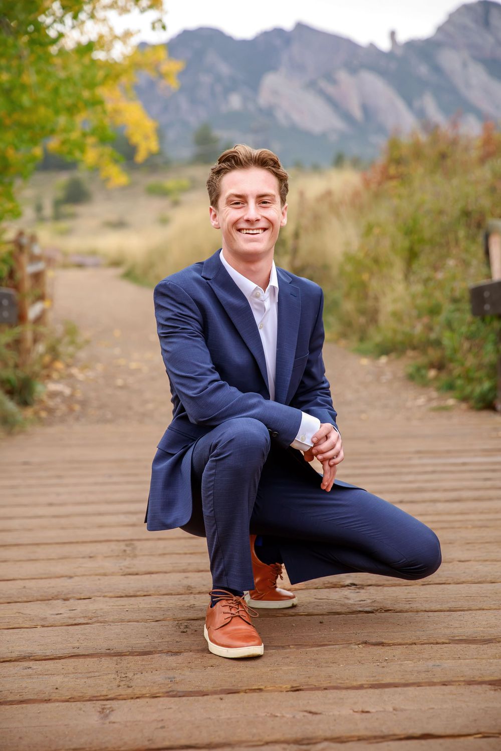 A series of casual outdoor portrait poses on a wooden boardwalk with mountains in the background.
