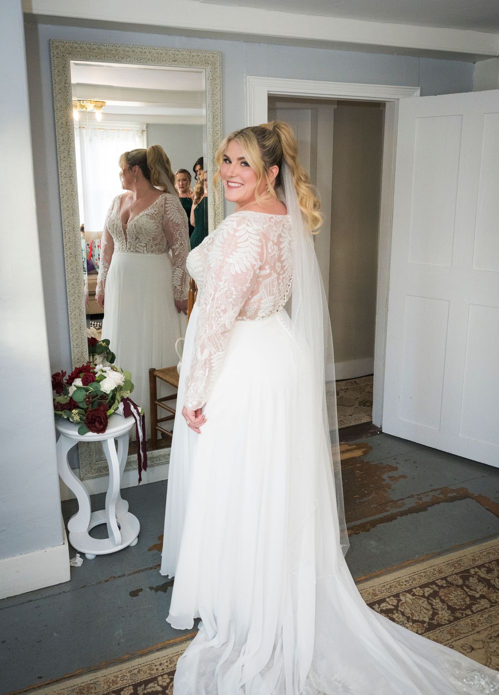 White lace wedding gown with flowing train photographed in sequence against neutral walls and wooden floors.