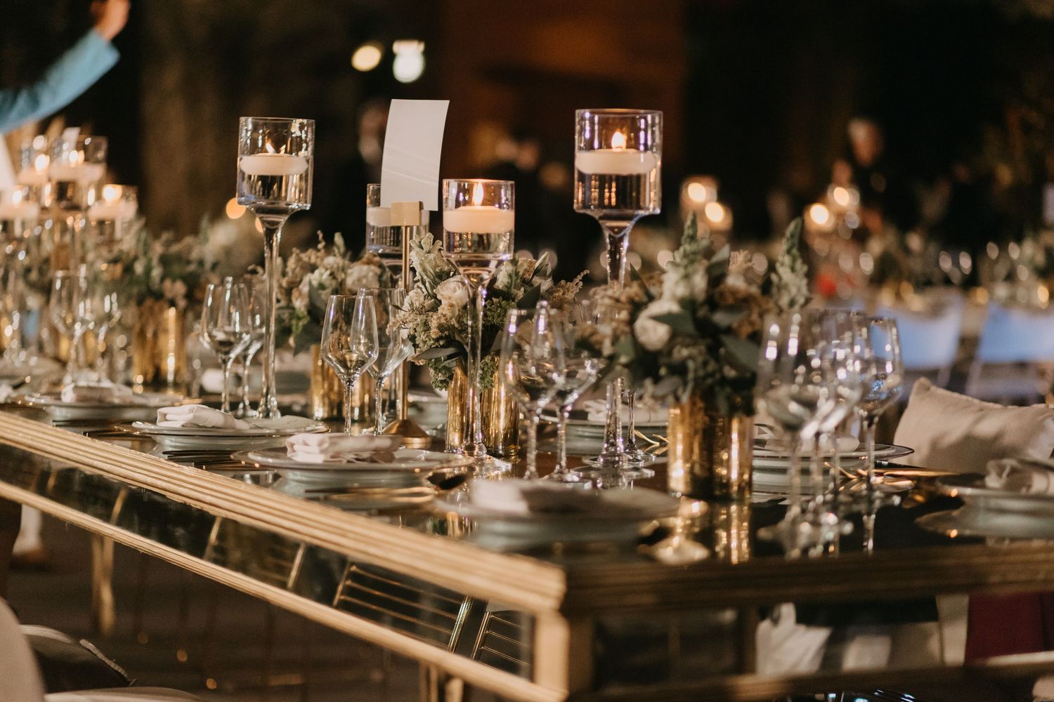 Elegant wedding reception table settings with crystal glassware and romantic candlelight decor.