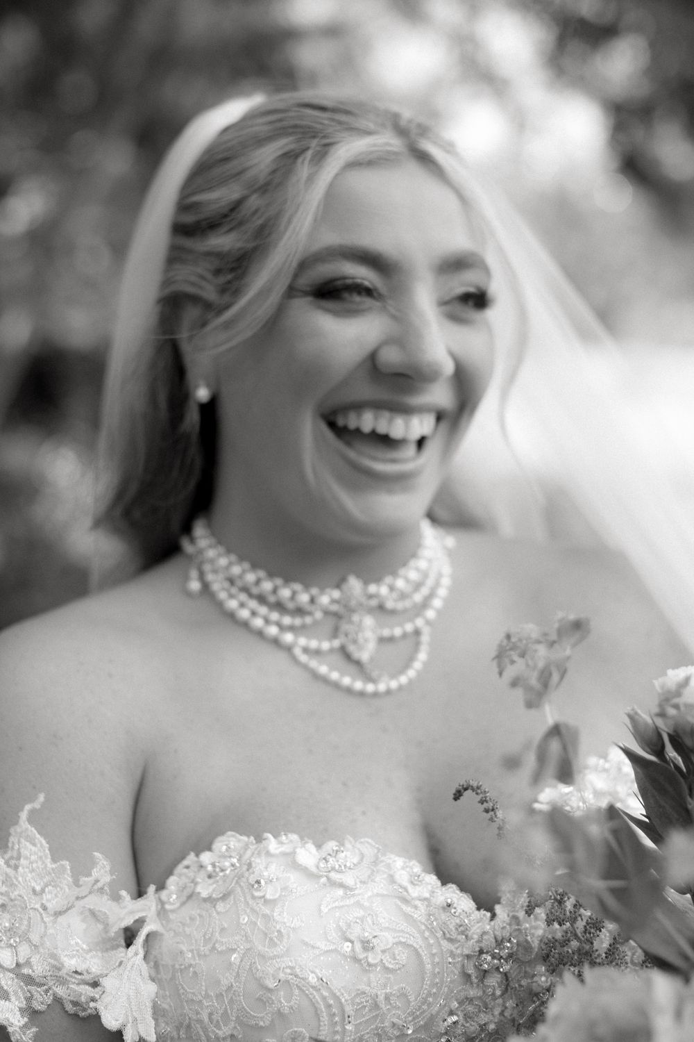 A series of black and white bridal portraits showing a pearl necklace and lace wedding dress details.