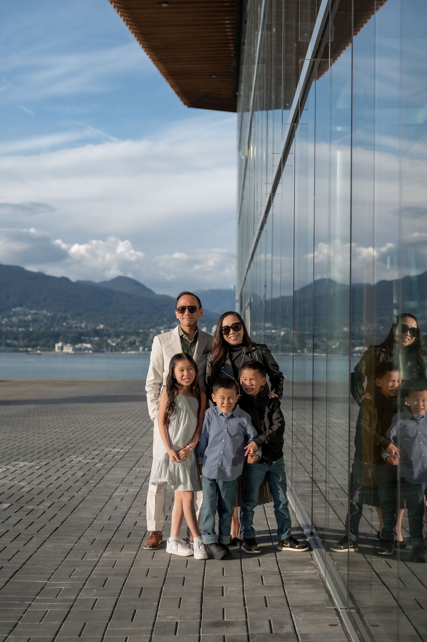Group enjoying scenic mountain views from glass observation deck at sunset in Vancouver.