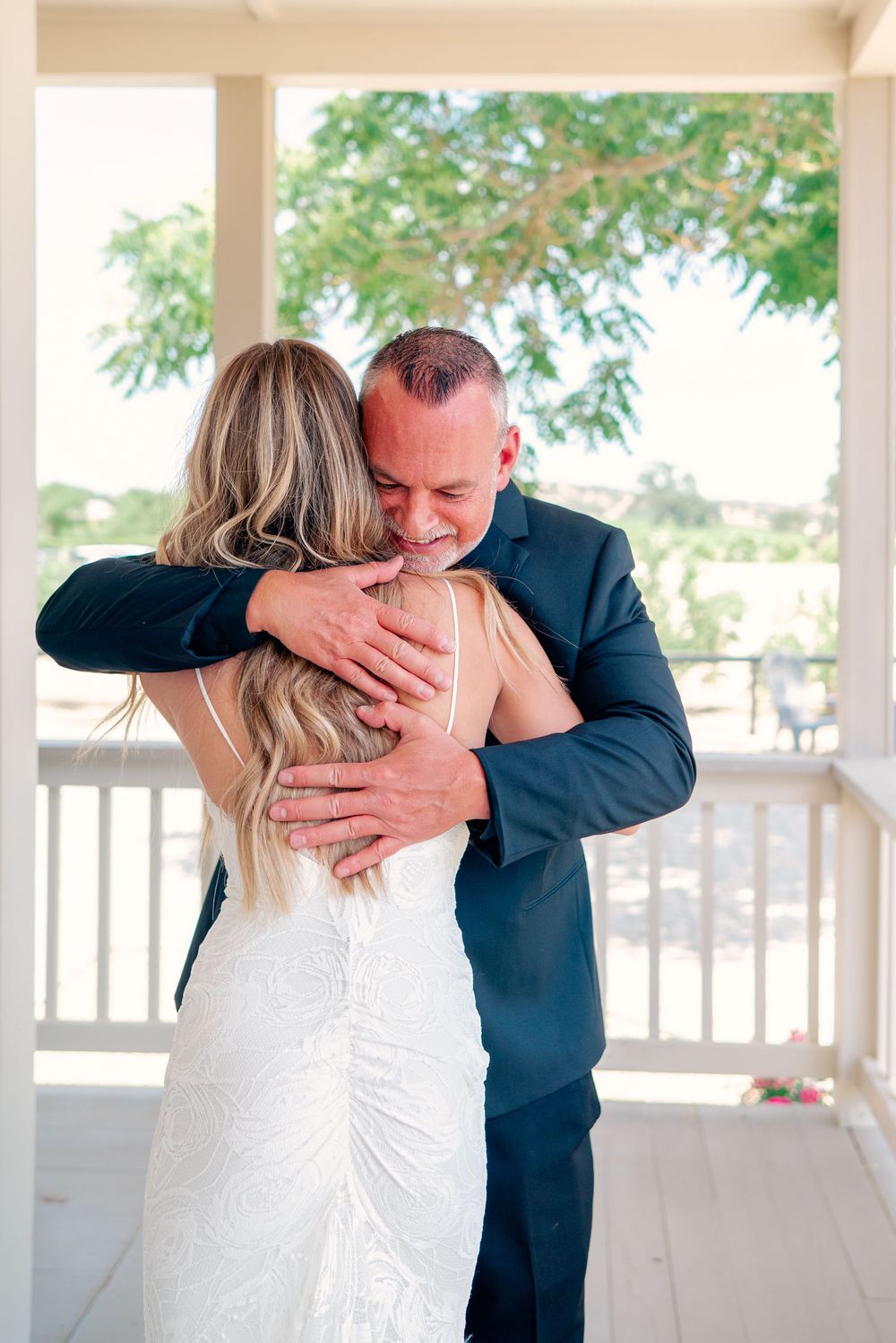 Emotional moment shared during first look on a covered porch.