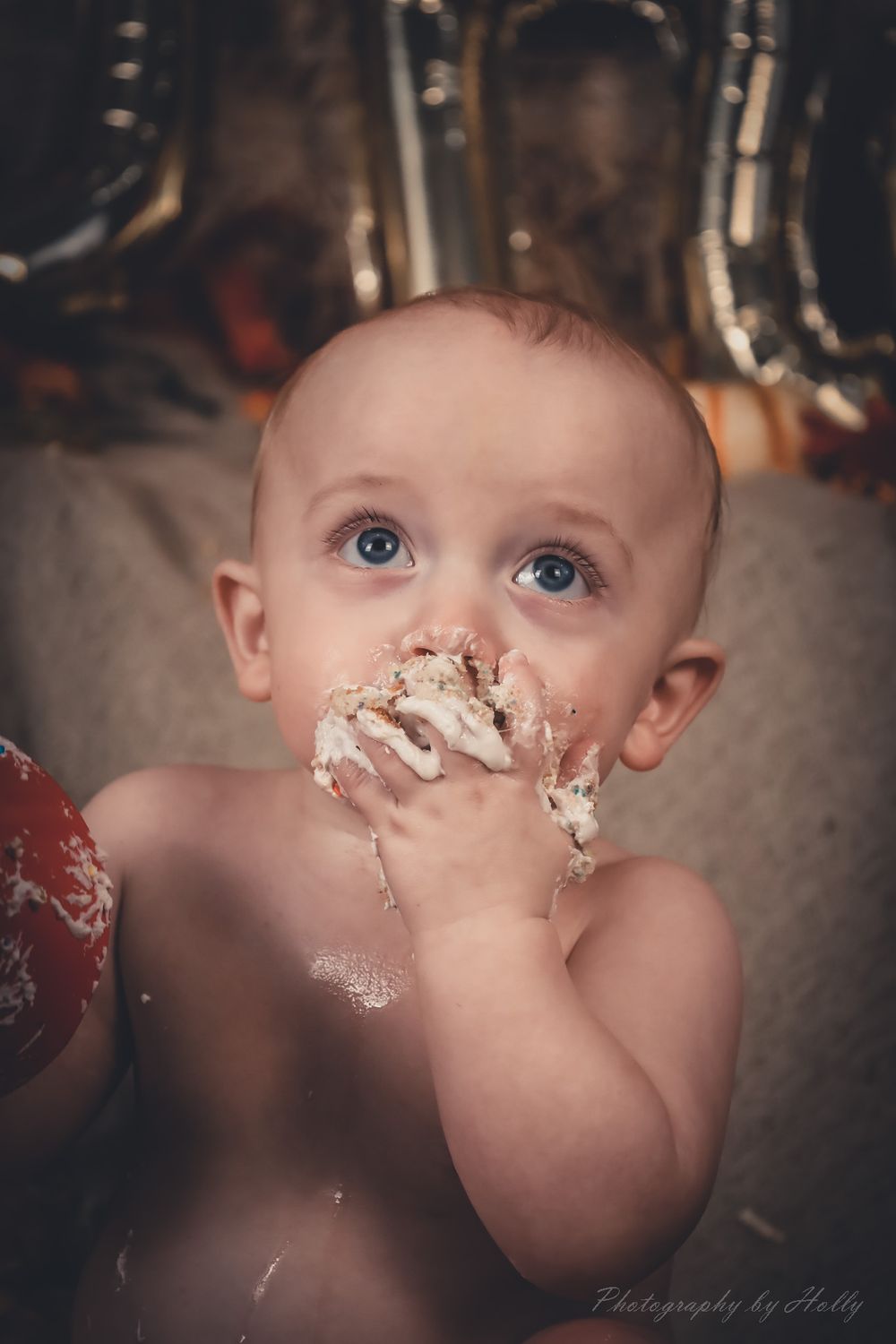 Close-up sequence of baby enjoying cake smash with frosting on face.