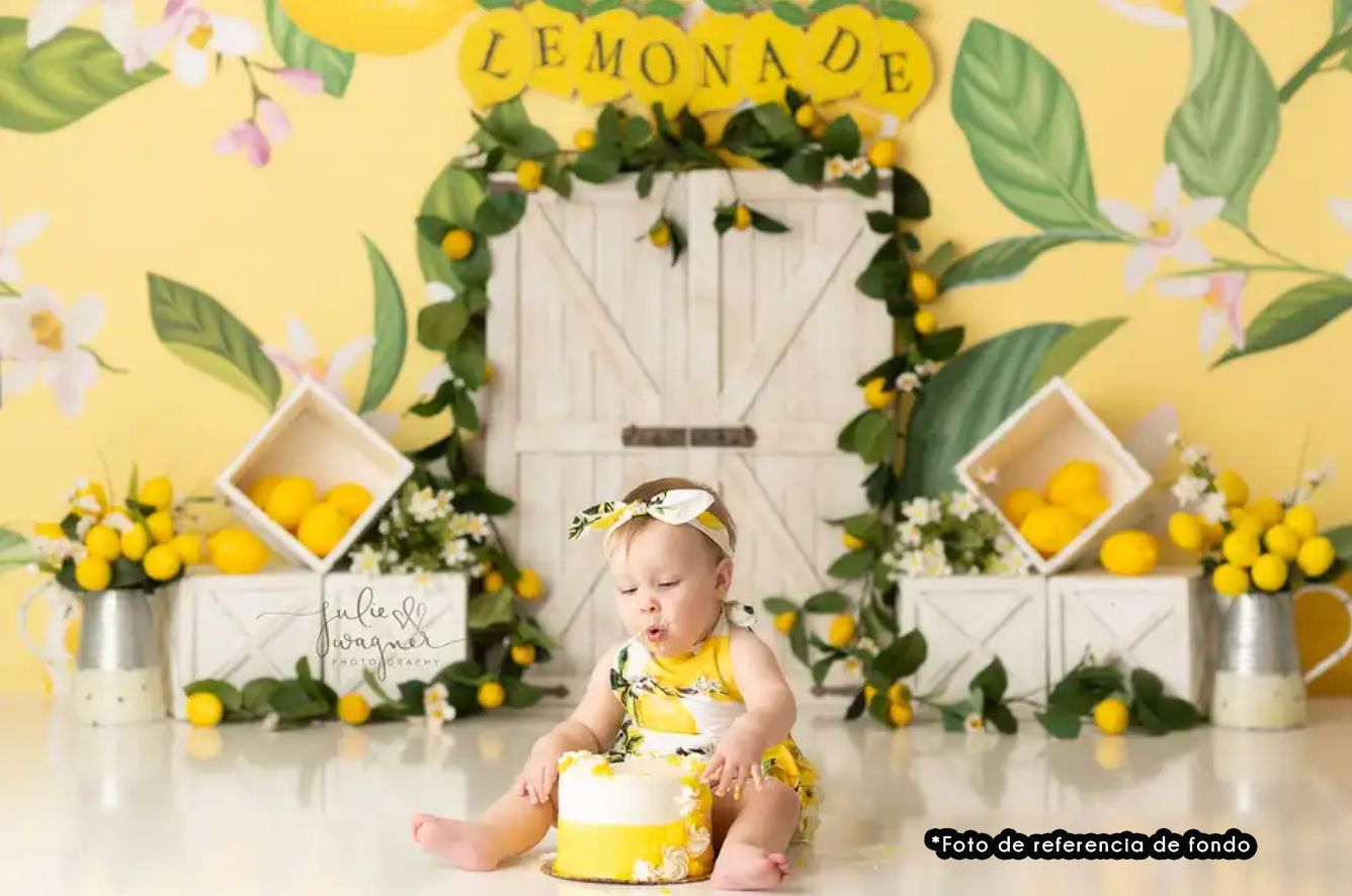 Yellow and white lemonade stand themed photo backdrop with floral decor and rustic wooden door centerpiece.