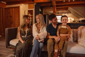 A cozy indoor family gathering on comfortable seating in warm lighting.