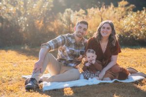 A family enjoys quality time together on picnic blanket during golden hour.