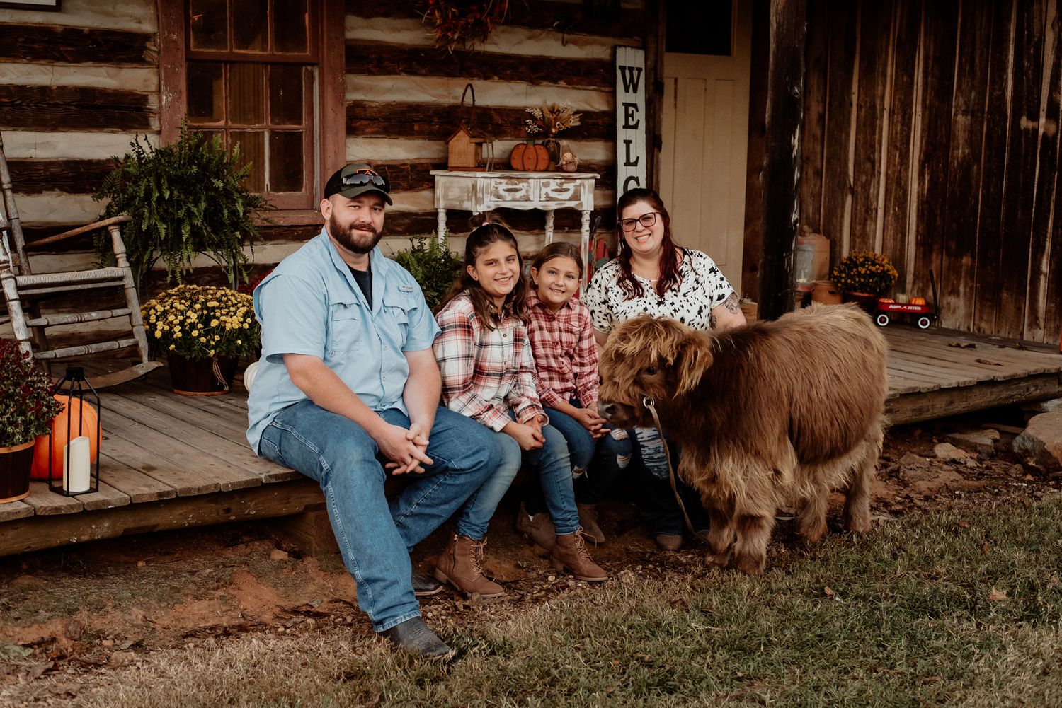 Family sitting on rustic porch with miniature pony in casual autumn setting.