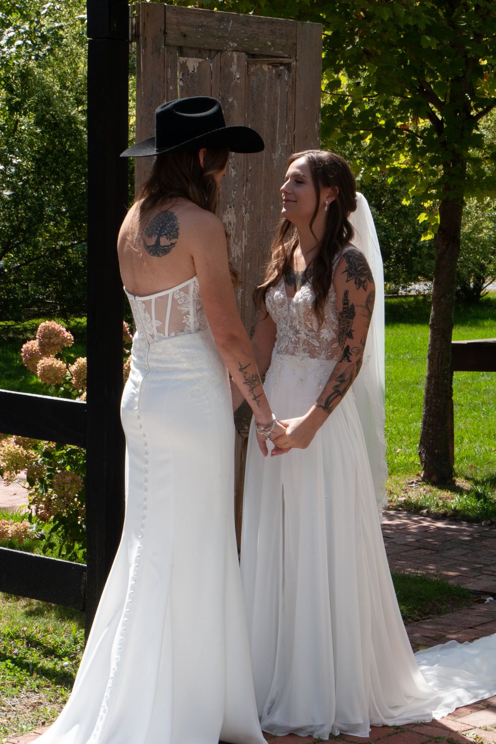 Two people in white wedding dresses sharing an intimate moment outdoors, lesbians,