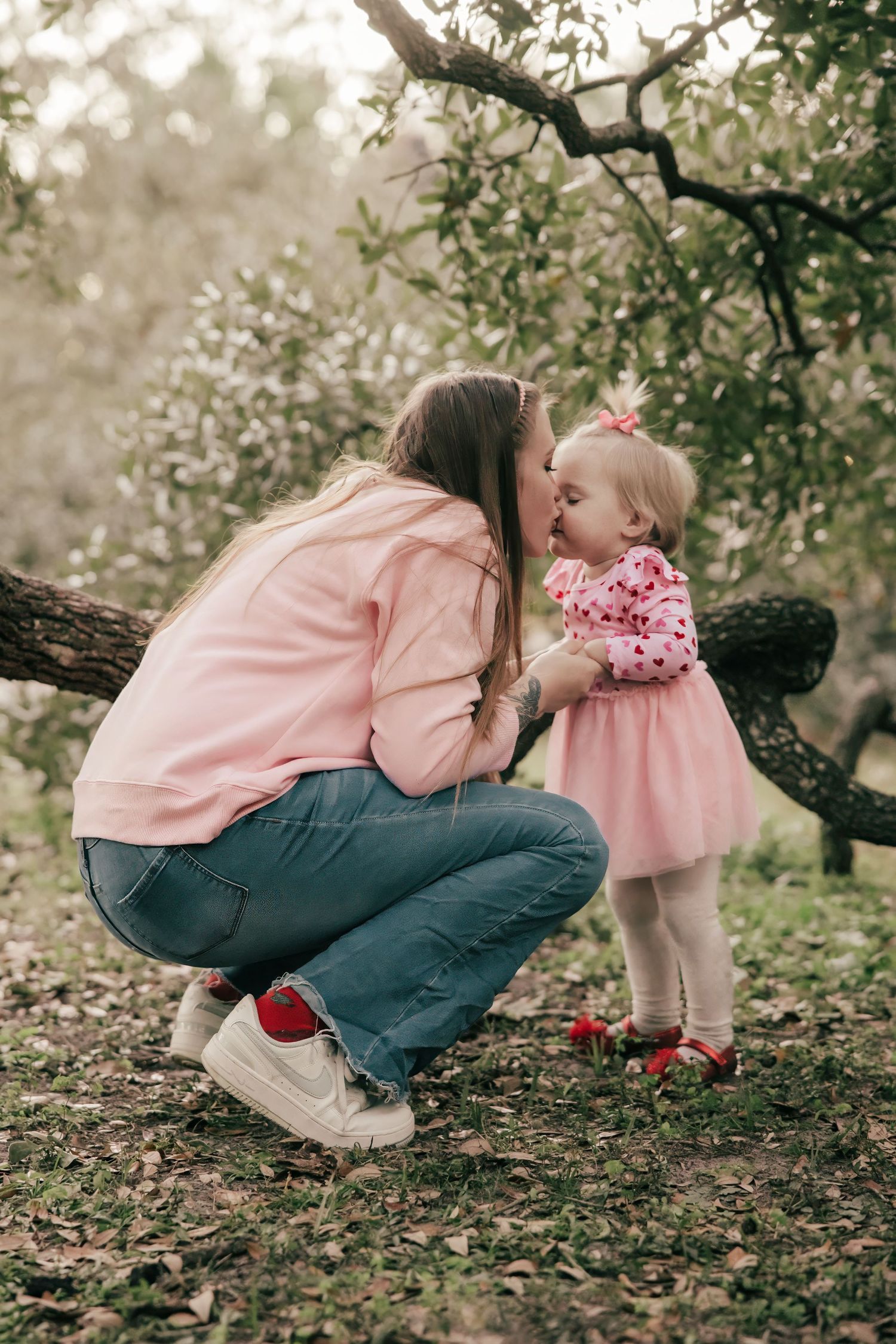 Sweet springtime moment under blooming tree branches in soft lighting.