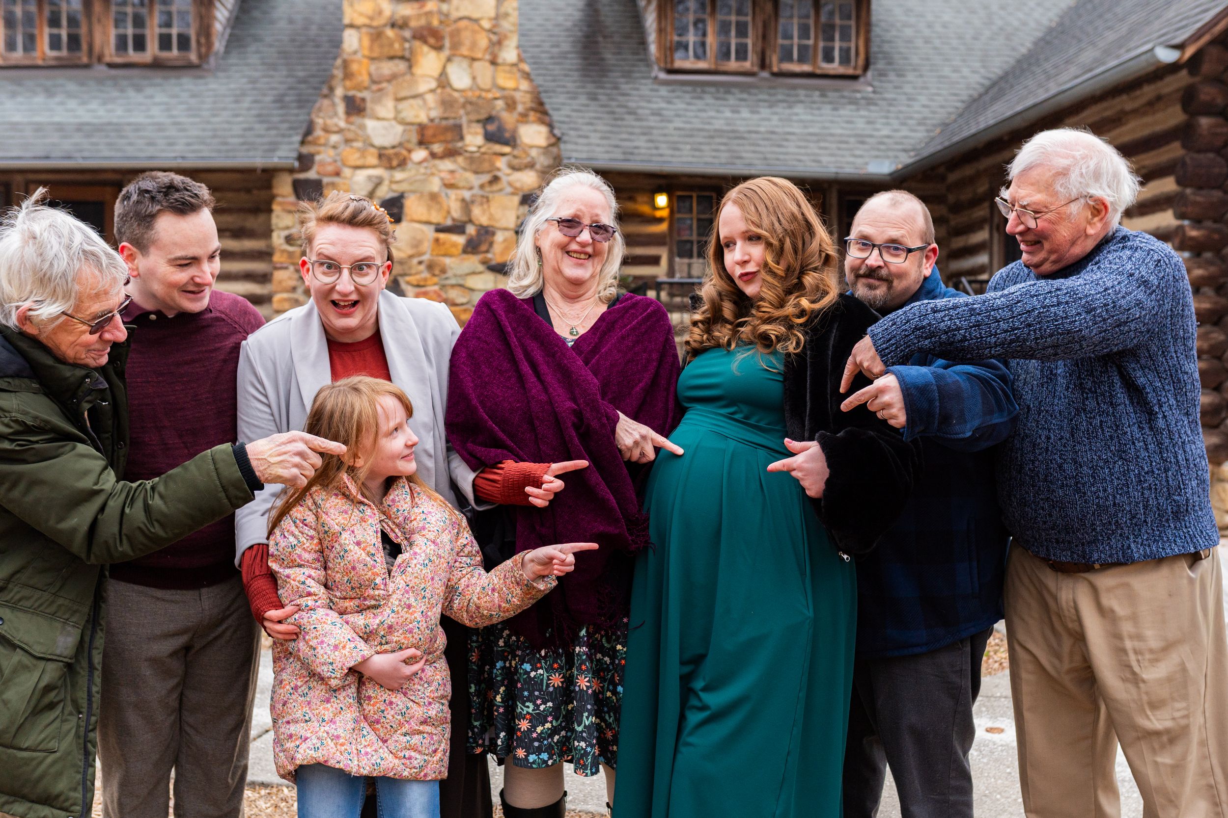 A joyful family photograph in front of a stone building.