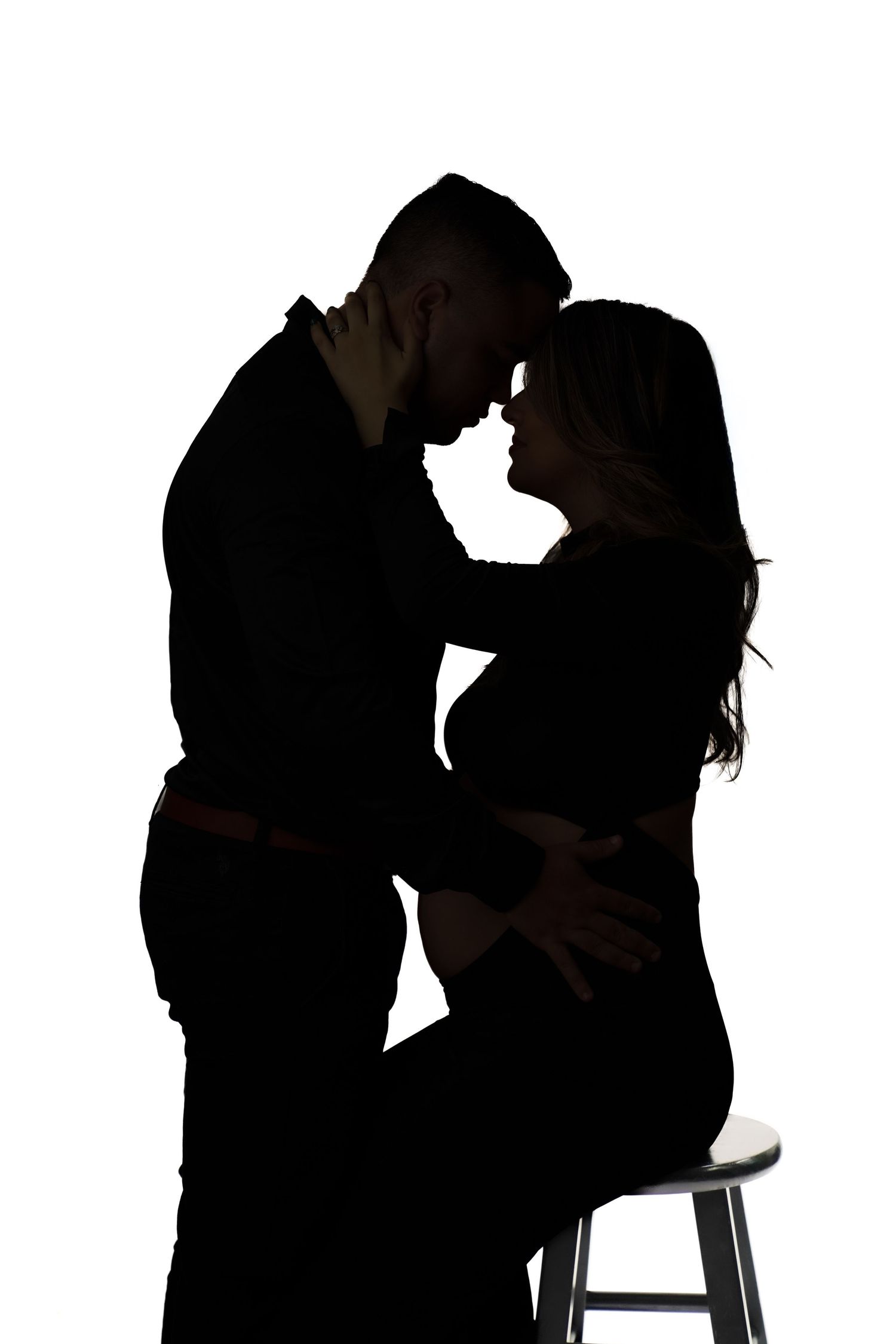 Dark silhouettes of couples dancing together against a white background create a romantic atmosphere.
