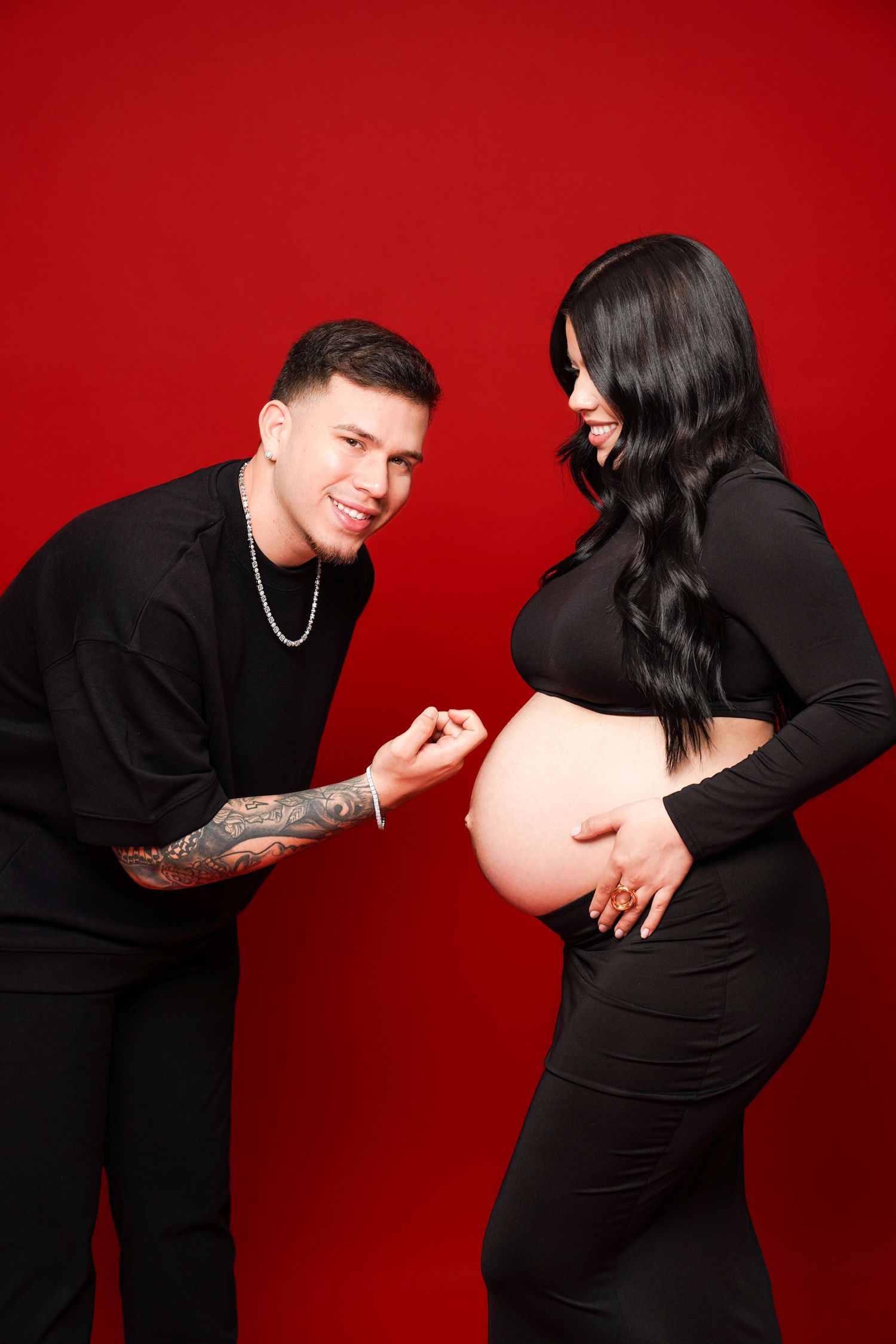 A series of intimate maternity photos showing a couple in black outfits against a red background.