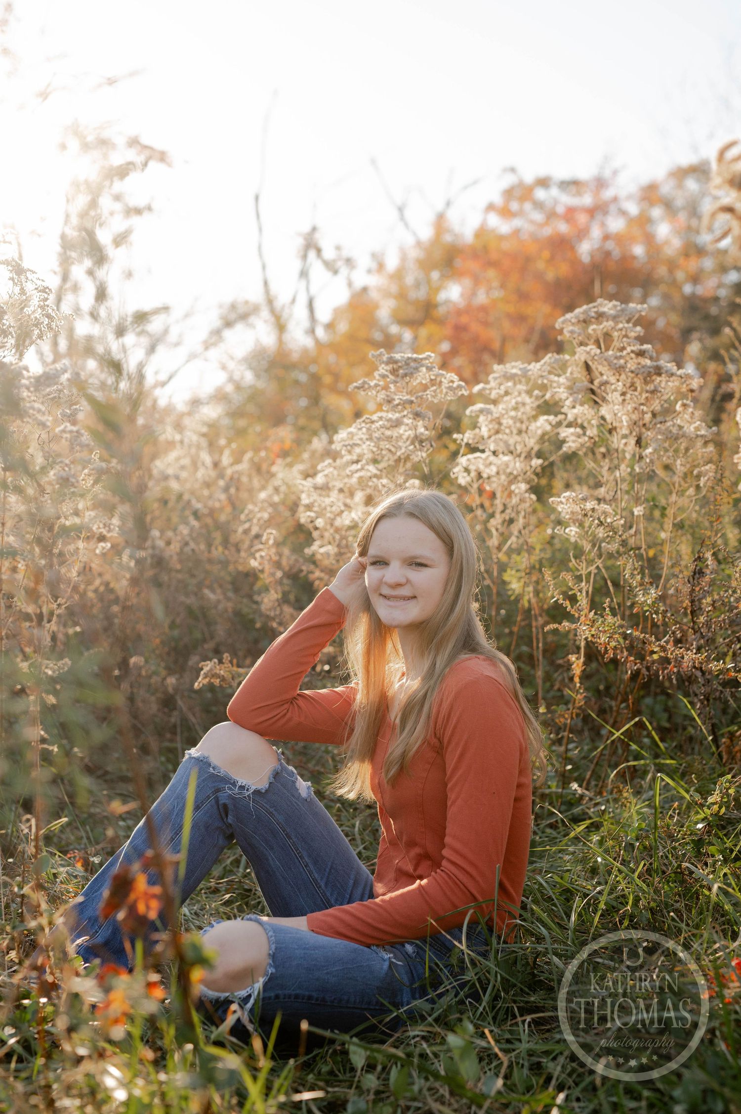 Natural light portrait in a meadow with golden hour lighting and autumn scenery.