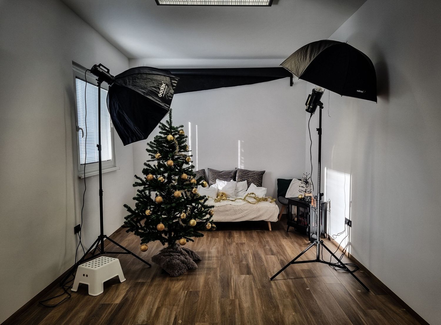 Majčken Studio v Hrastniku – sodoben fotografski studio z lesenimi tlemi, belimi stenami, lučmi in božično postavitvijo za fotografiranje.