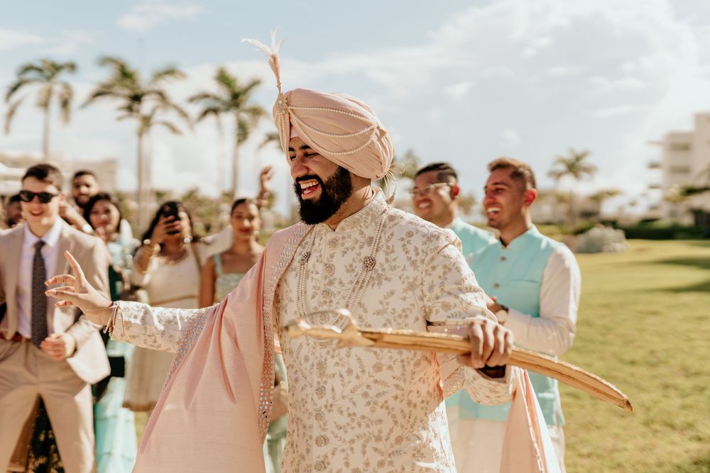A Sikh wedding celebration on a sunny beach resort lawn with guests in traditional attire.