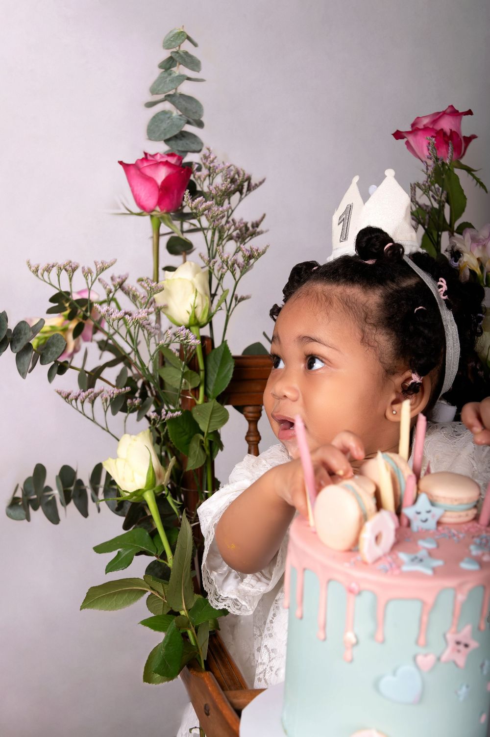 A joyful scene with pink roses and a pastel blue birthday cake against a light background.