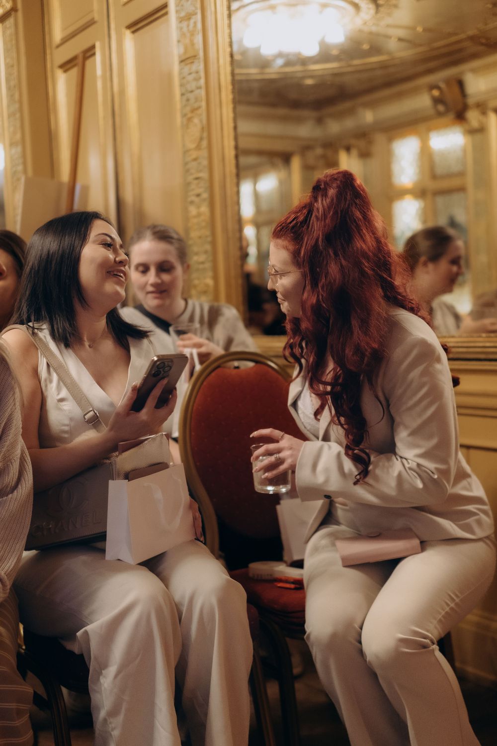 women holding goodie bags, laughing in a conference room while being captured by conference photographer in Stockholm