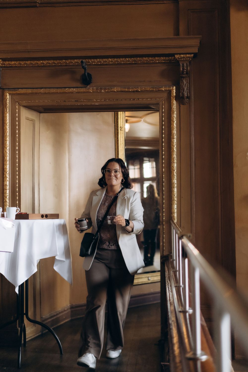 woman holding a drink walking towards camera while being captured by experienced event photographer in Stockholm