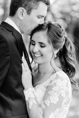 An intimate black and white portrait of newlyweds sharing a tender moment.