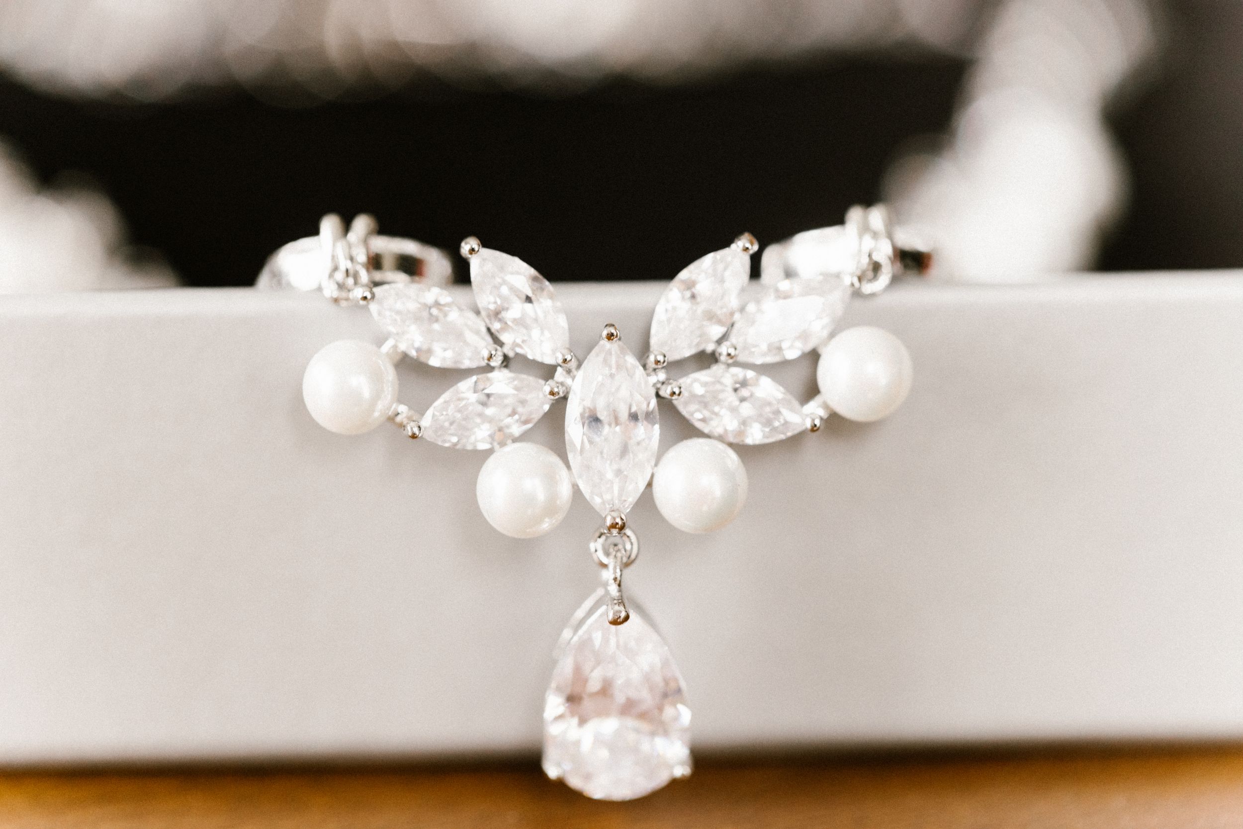 An elegant pearl and crystal bridal necklace displayed on a white surface.