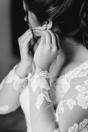 Close-up detail of lace sleeves on a wedding dress in black and white.