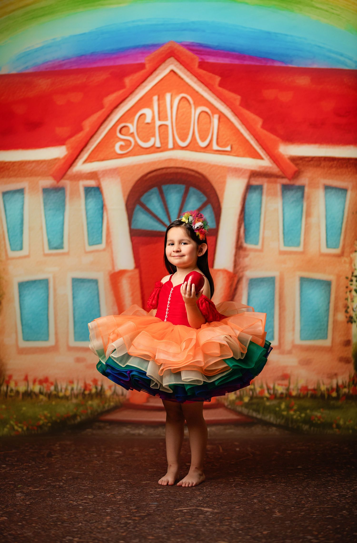 Purple tulle dress portrait with large bow backdrop and floral decorations.