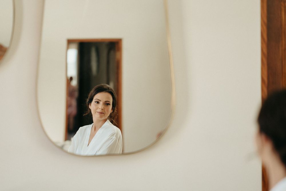 Mirror reflection in an elegant white room with curved architectural details.