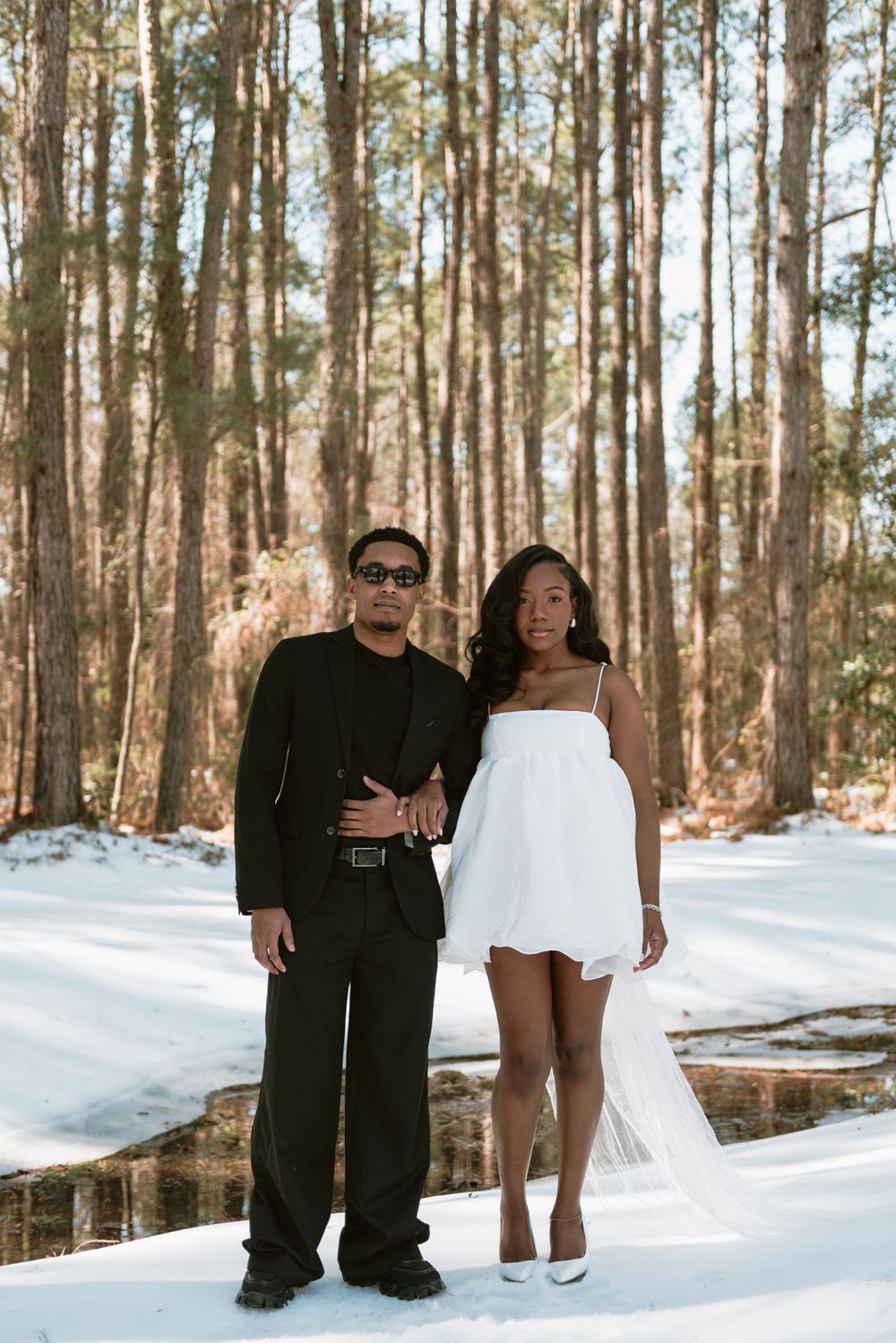 A bride and groom standing side by side posing for the camera.