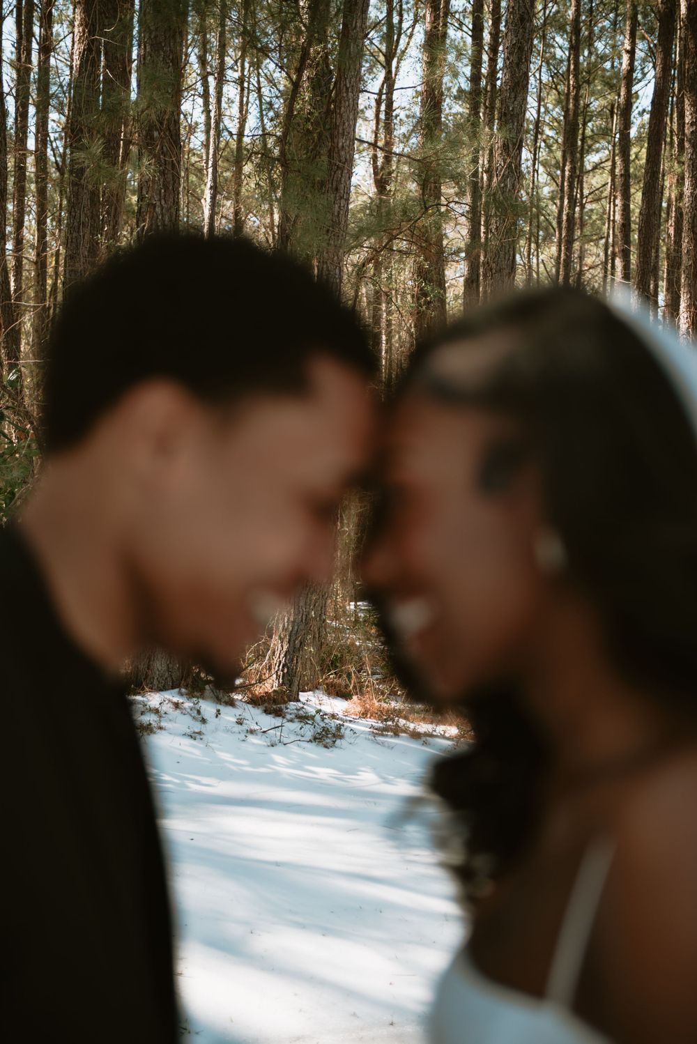 A blurry image of a couple forehead to forehead smiling and posing together.