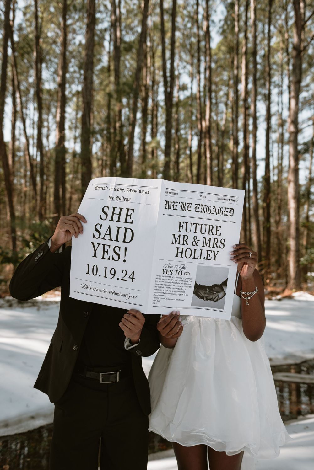A couple holding a newspaper announcing their engagement.
