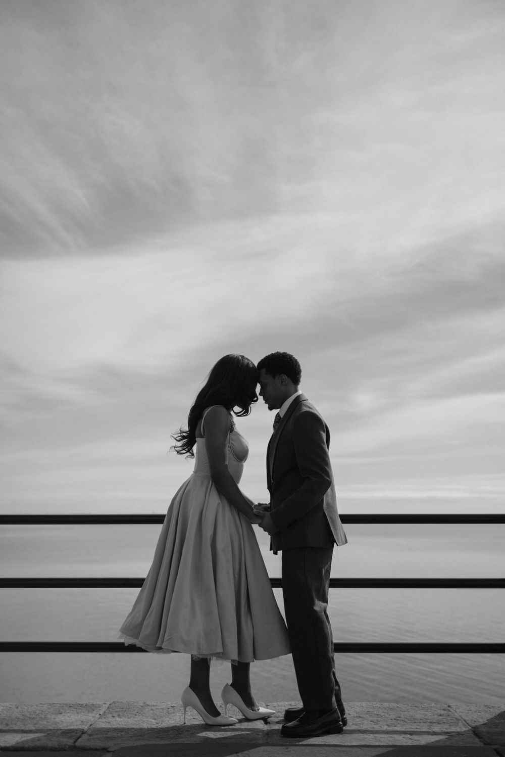 A black and white image of a couple posing forehead to forehead.