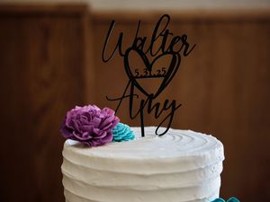 White wedding cake with purple rose and teal accents featuring a black name topper.

Indiana Weddings
Illinois Weddings
Michigan Weddings