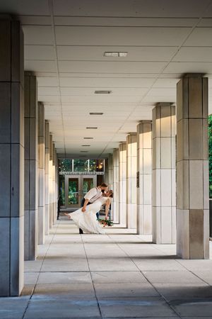 A series of architectural columns create a dramatic perspective in a modern covered walkway with natural light.
