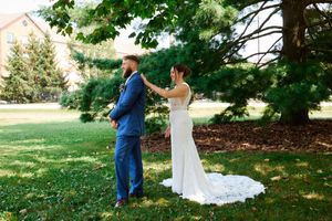 A couple shares their first look moment in a garden setting during their wedding day.