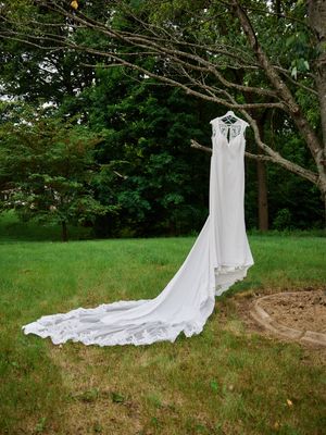 An elegant wedding dress with a long train hangs from a tree branch.
Indiana Weddings
Illinois Weddings
Michigan Weddings
Weddings