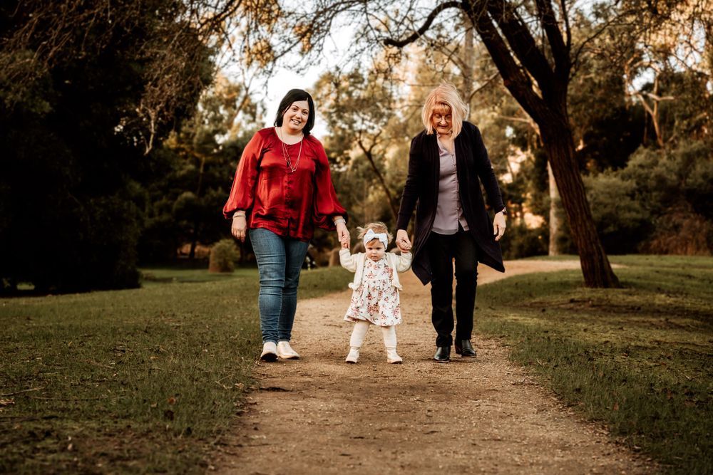 Family walking together on autumn path through park.