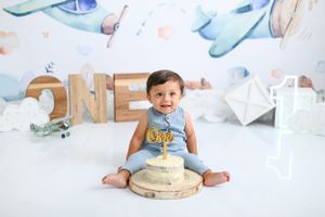 First birthday cake smash setup with watercolor backdrop and ONE lettering display.