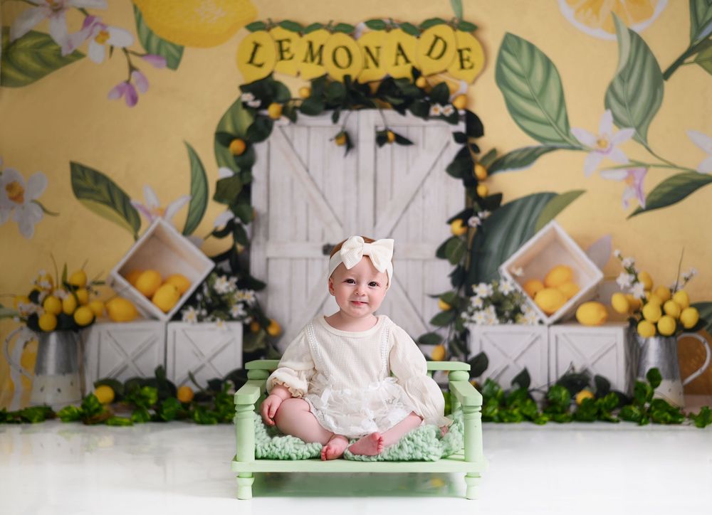 A decorated scene with white wooden doors, floral garlands, yellow flowers and green foliage backdrop for a photo setting.