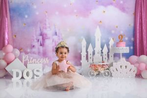 Princess themed photo setup with castle backdrop, pink balloons, and DOS lettering.