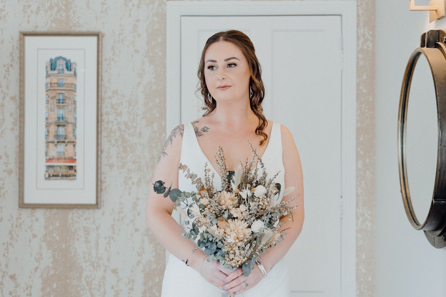 A bride in a white gown holds a romantic bouquet of white and pale blue flowers, captured by Apertured Media Auckland Wedding Photographer.