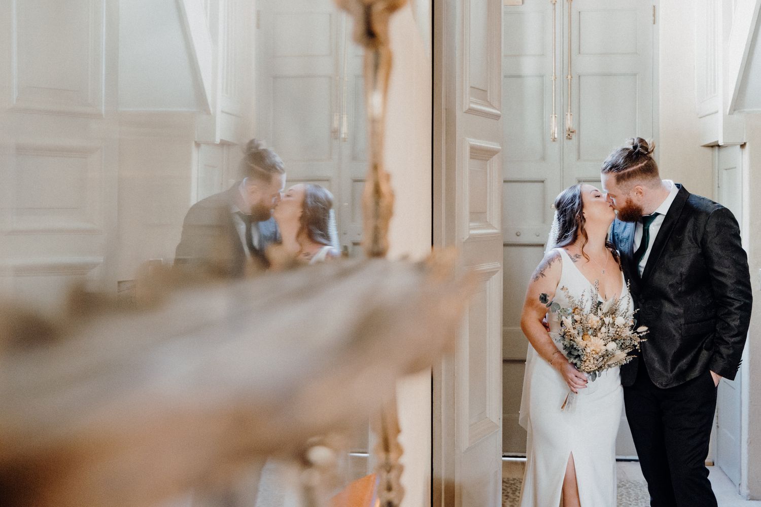 Newlywed couple in an intimate moment in a doorway during their wedding ceremony, captured by Apertured Media Auckland Wedding Photographer.