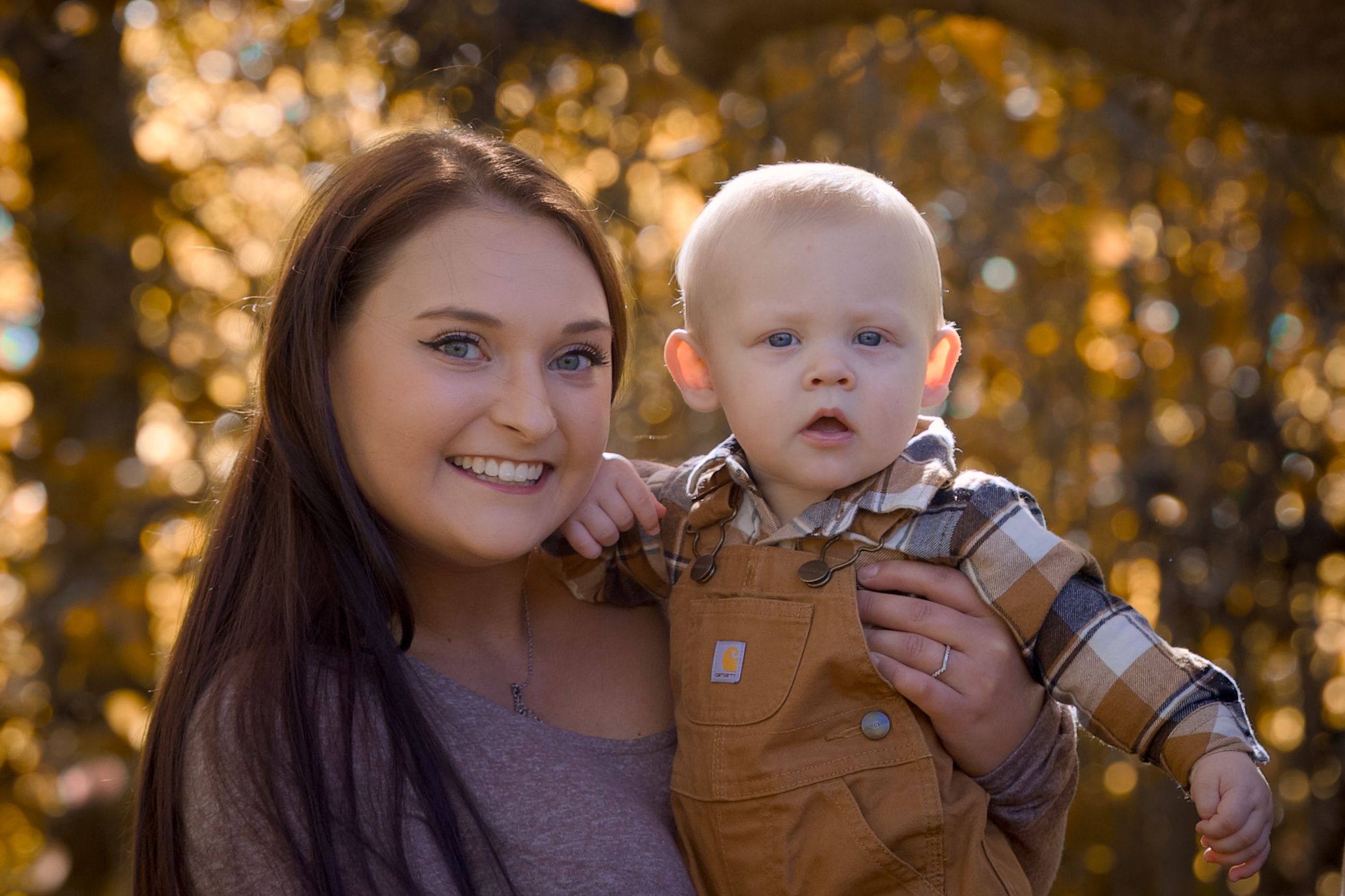 A group of five similar photos showing a parent and baby outdoors in autumn with golden sunlight filtering through trees.