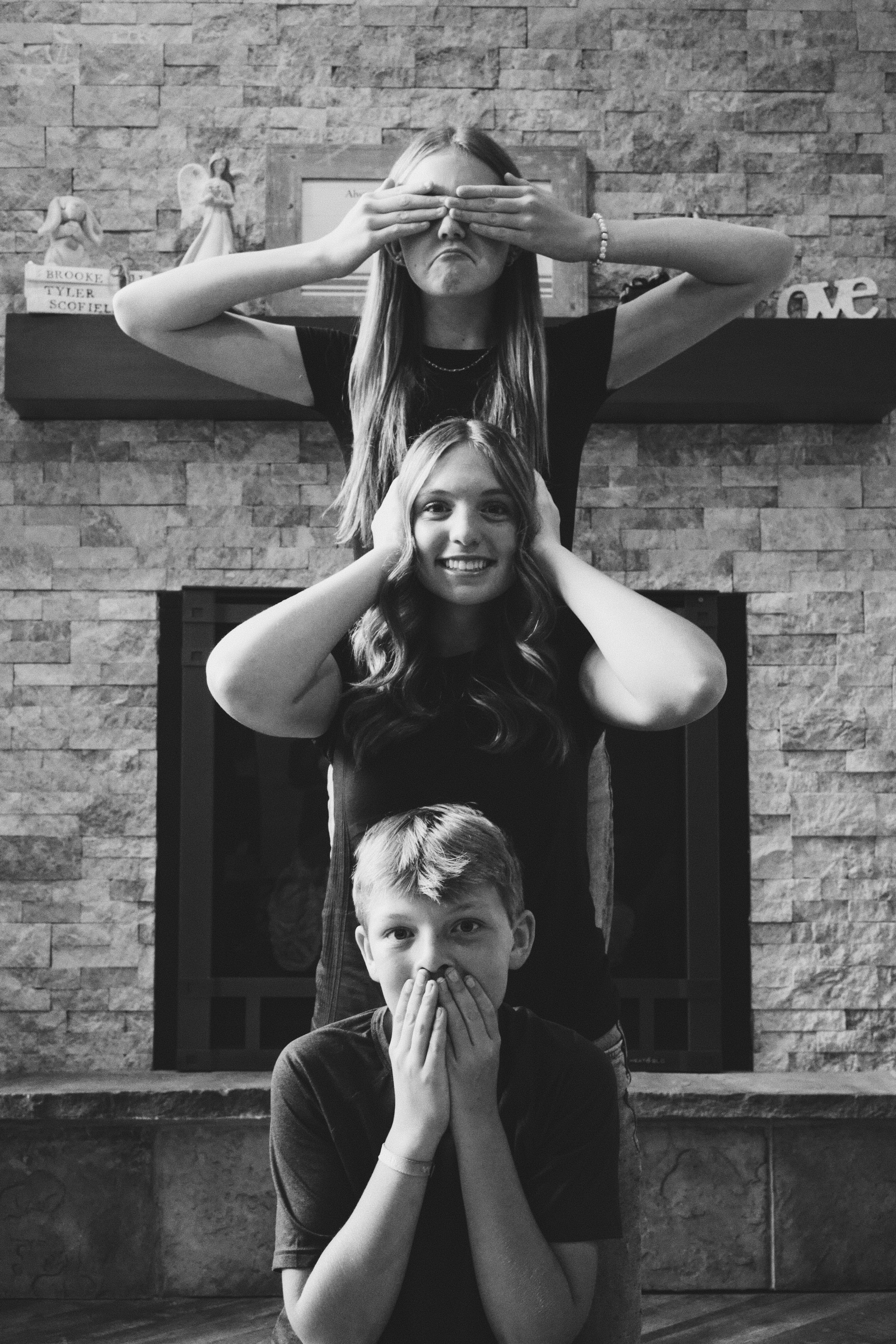 Black and white photo series showing three poses mimicking see no evil, hear no evil, speak no evil monkeys.