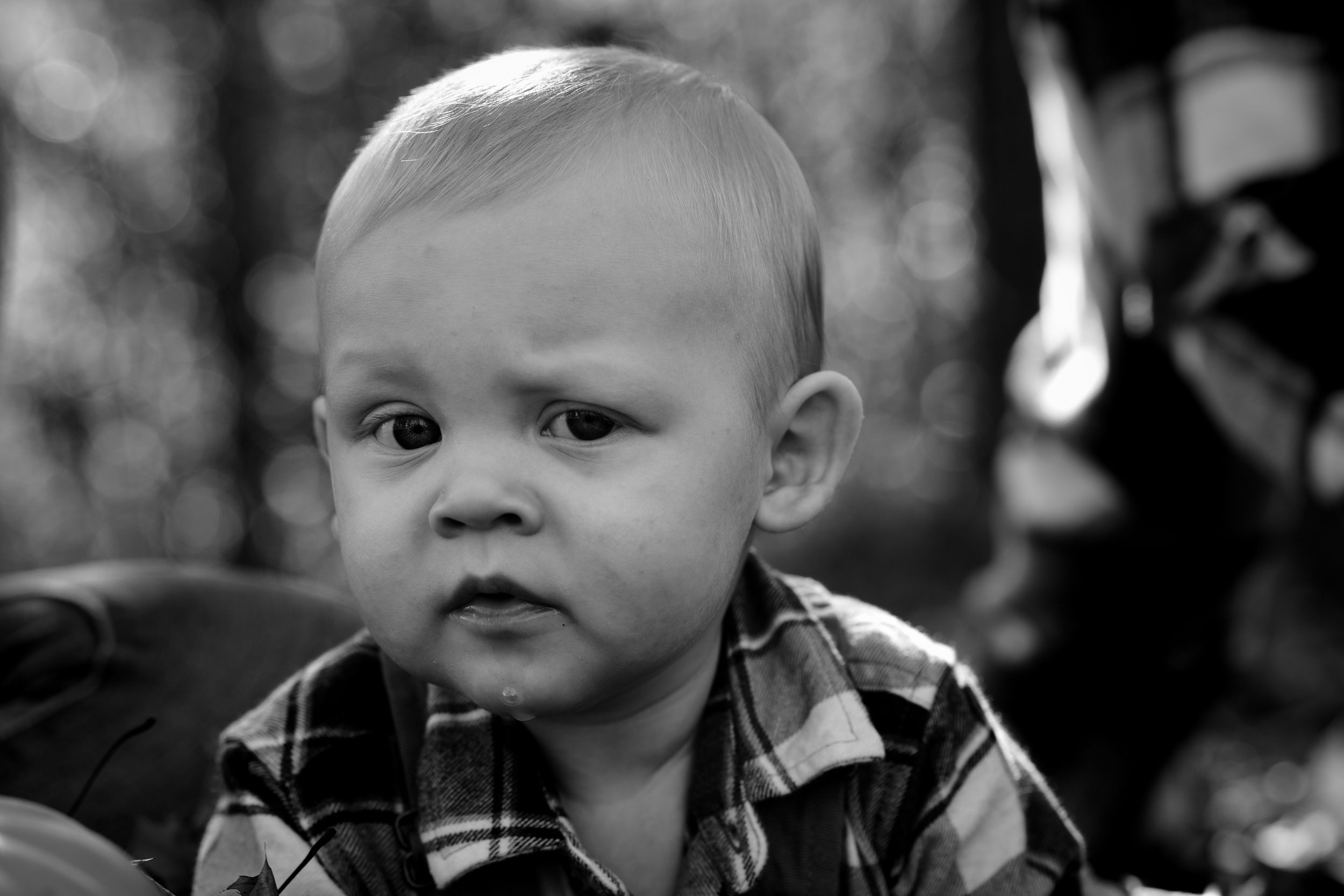 A black and white collage of four candid baby expressions showing various emotional reactions.