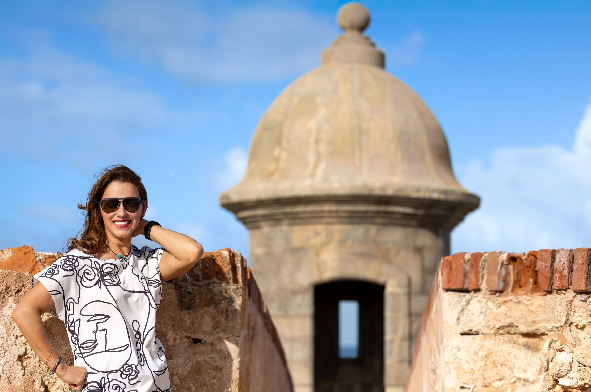 Historic stone fortress with domed guard tower against blue sky in Puerto Rico.