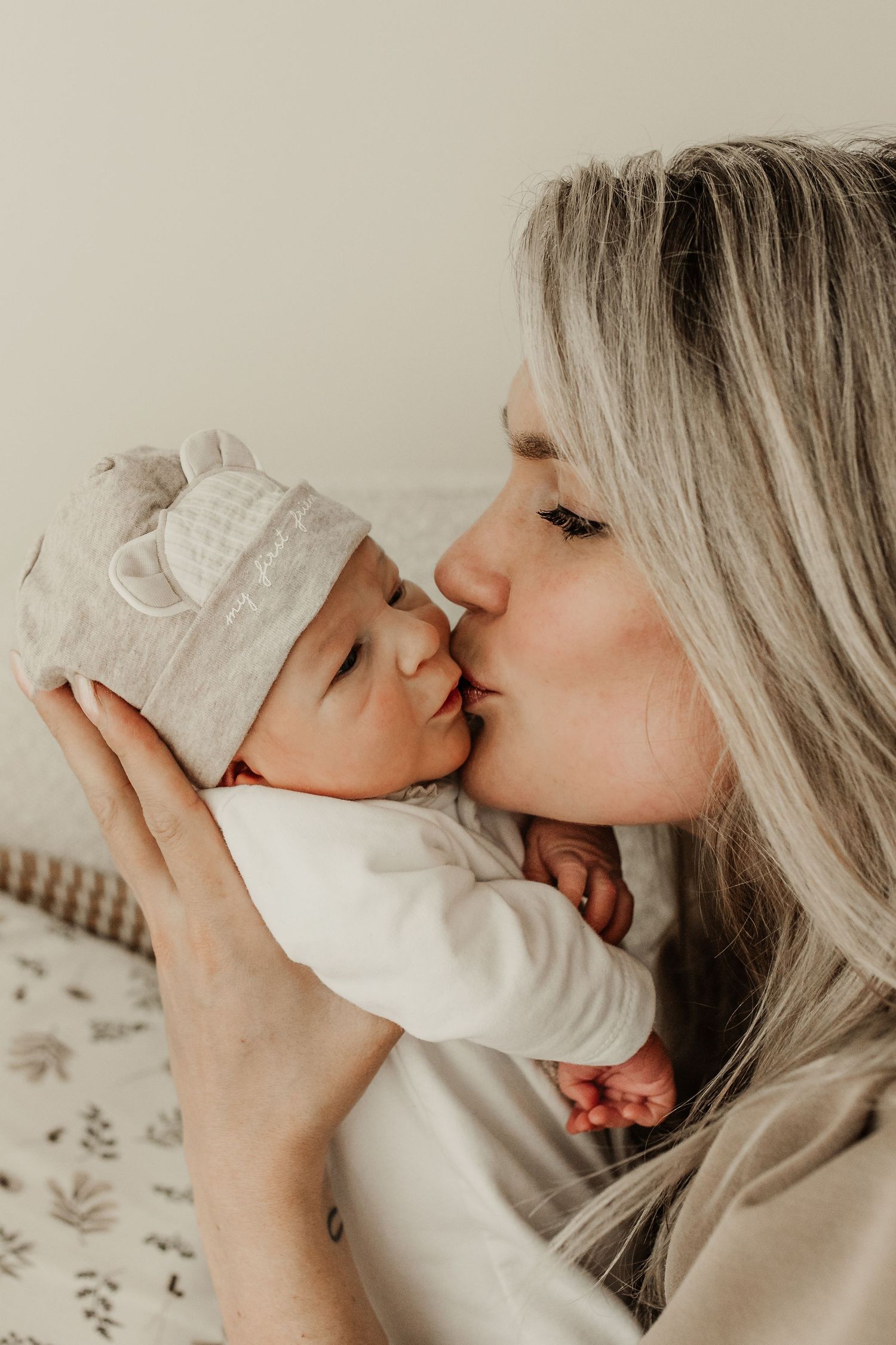 moeder kust pasgeboren baby tijdens intieme newborn fotoshoot in studio
